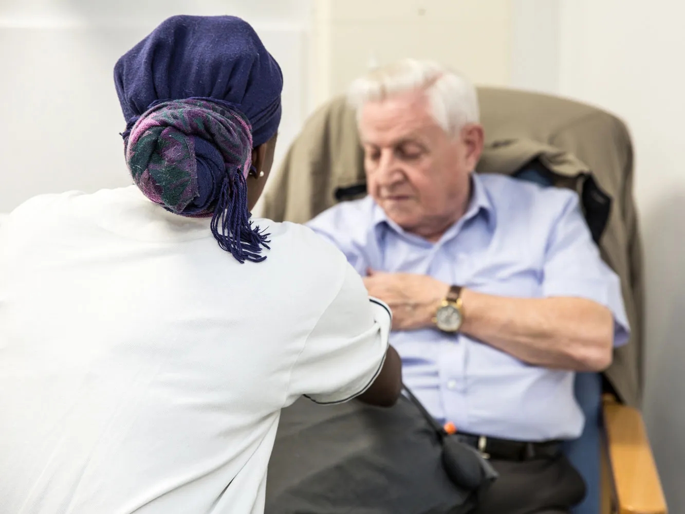 woman with head scarf helping a patient
