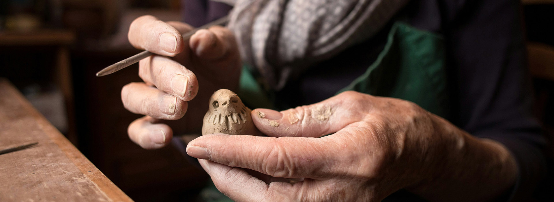 hands crafting clay bird figure
