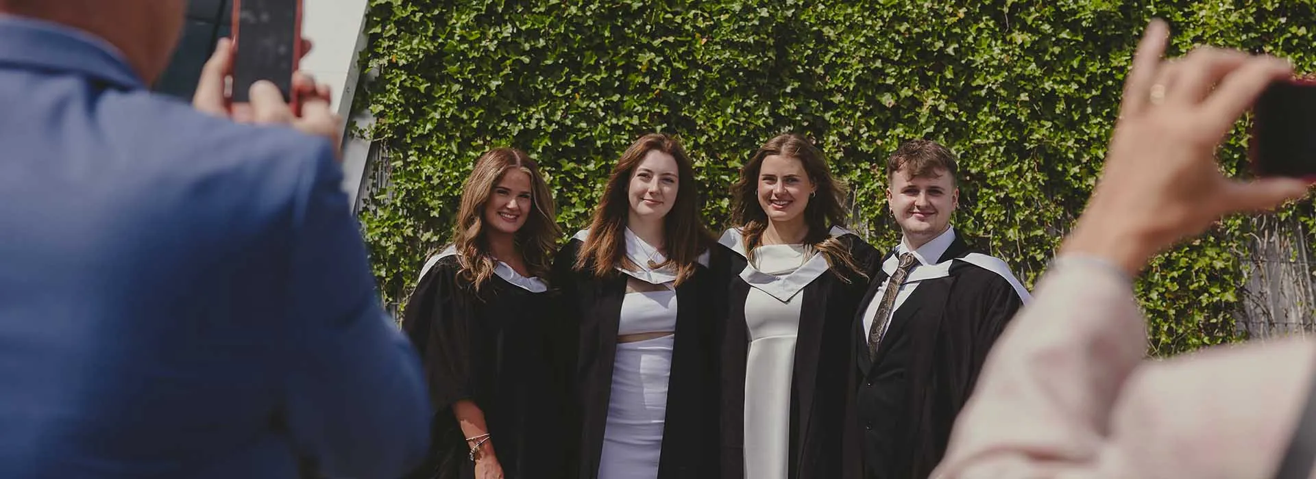 Parents taking photographs of loved ones at graduation