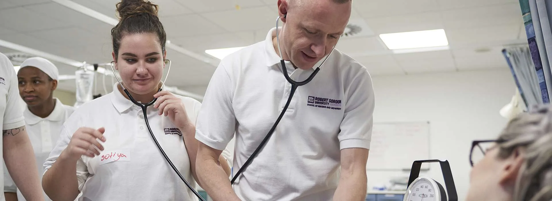 students using a stethoscope on a patient
