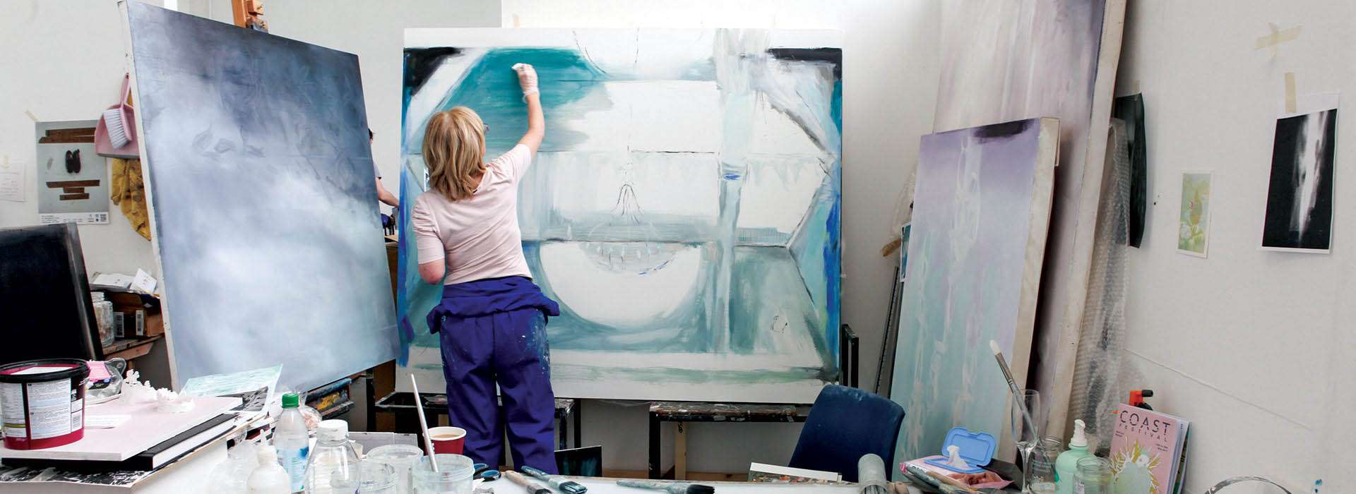 woman painting on a large canvas