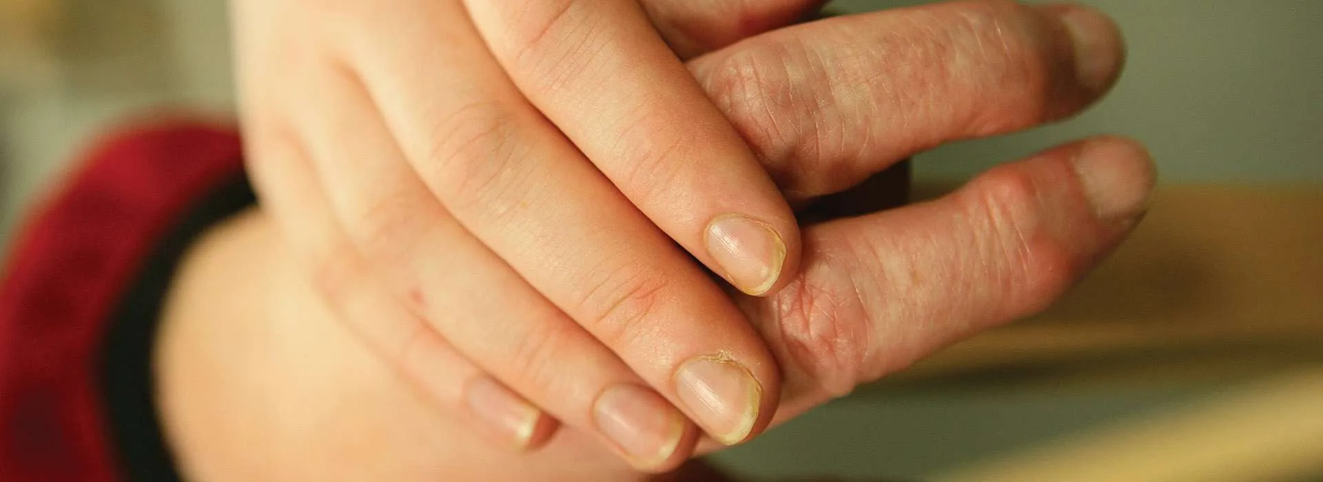 younger hand holding older hand