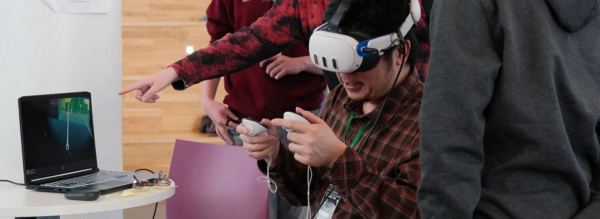 Students at the hackathon using computers and controllers