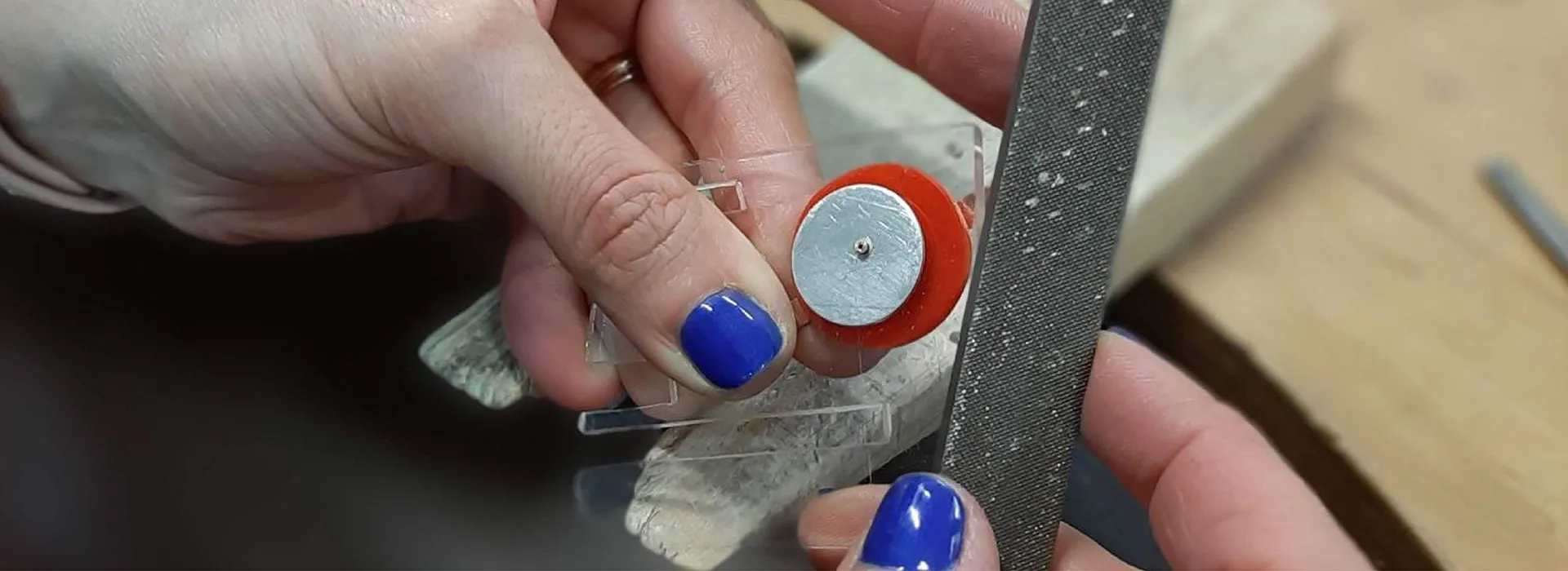 Person using a file on some jewellery