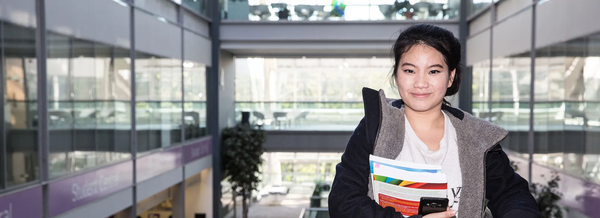 student holding books on campus