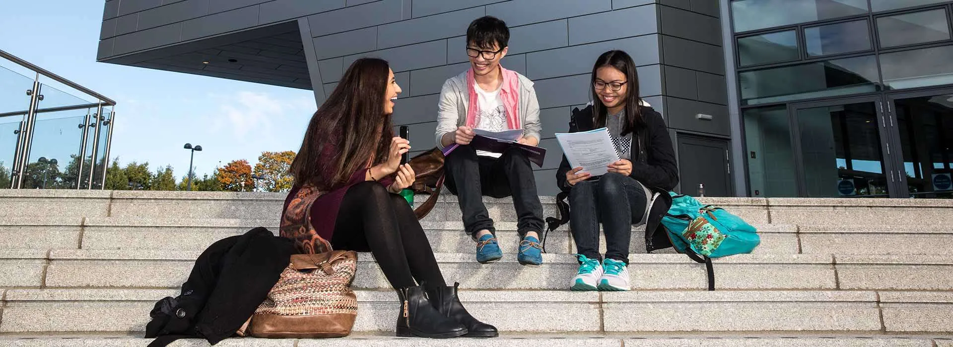 students sitting on the steps near Sir Ian Wood Building
