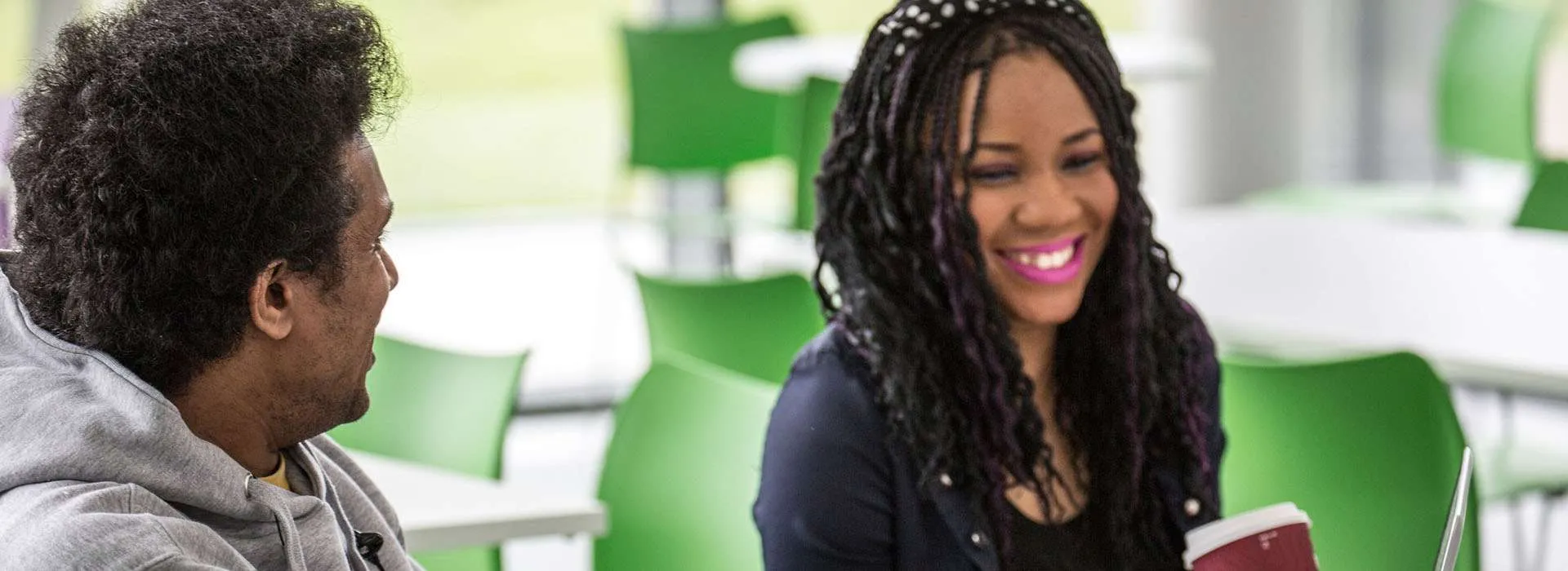 two students laughing in a cafeteria