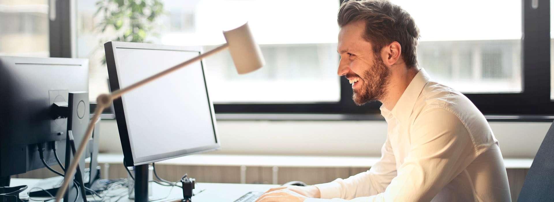 man smiling at computer screen