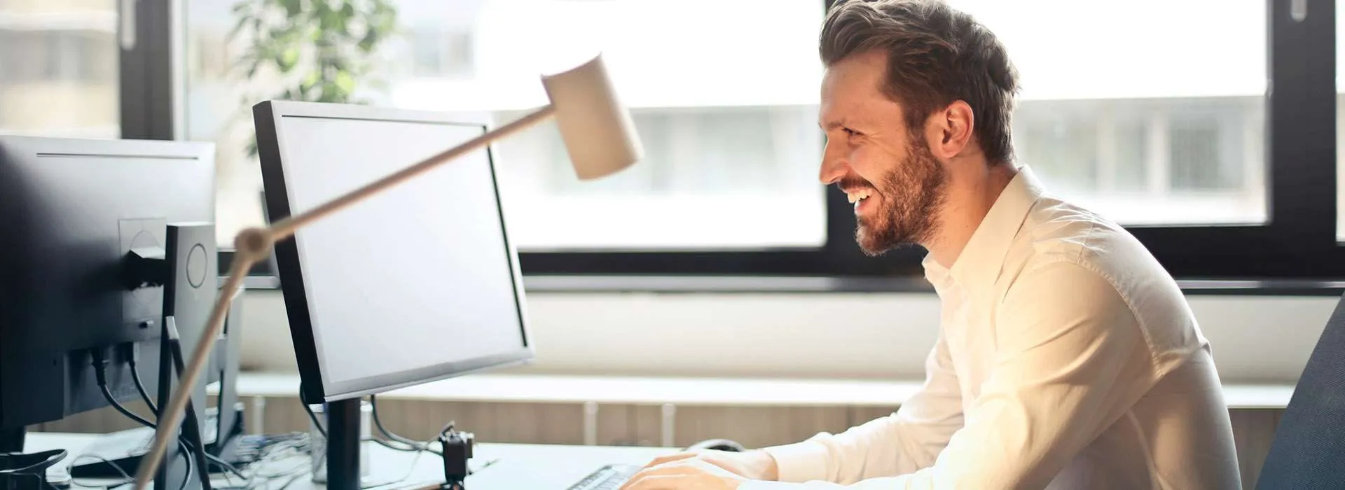 man smiling at computer desk