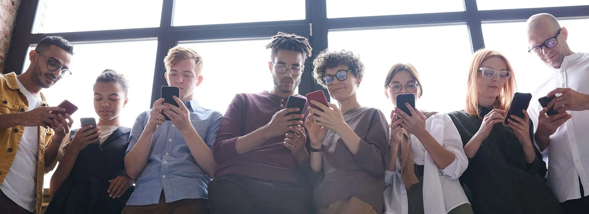 a group of young people all staring at their phones