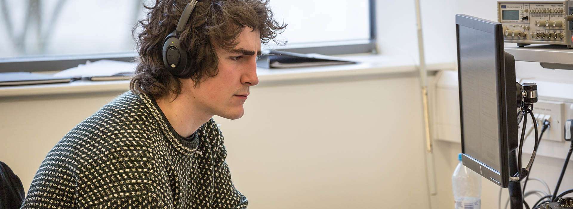 student looking at computer in lab