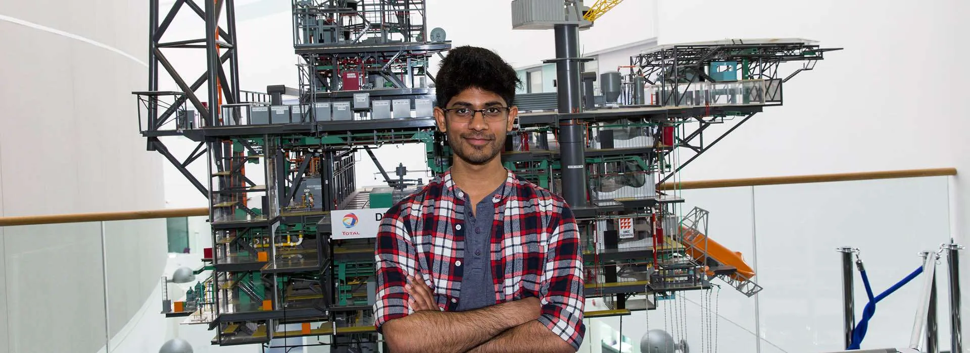student in front of oil rig model