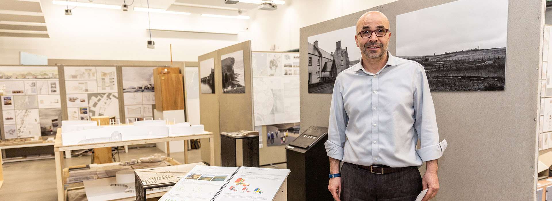 man standing in front of degree show display