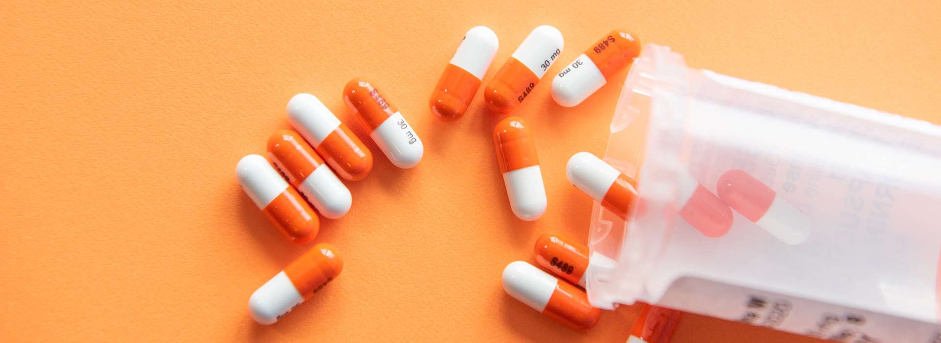 orange pills spilling out of a container