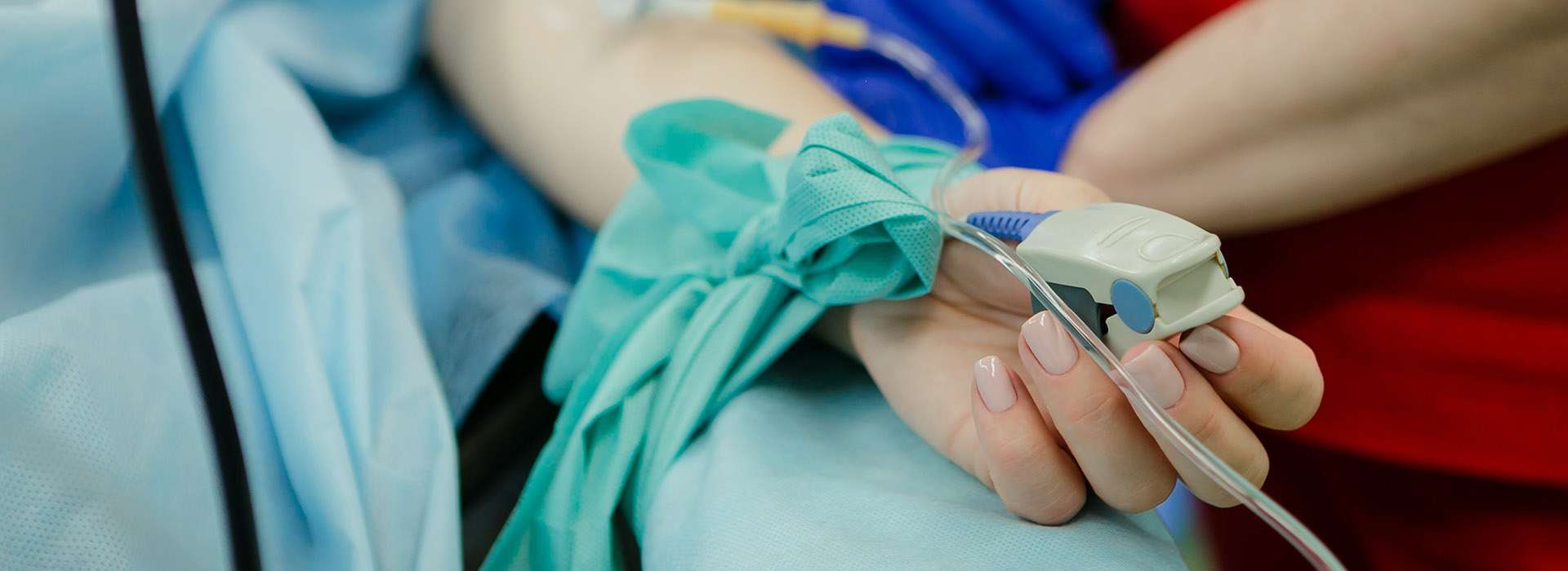 patient with an IV and pulse oximeter