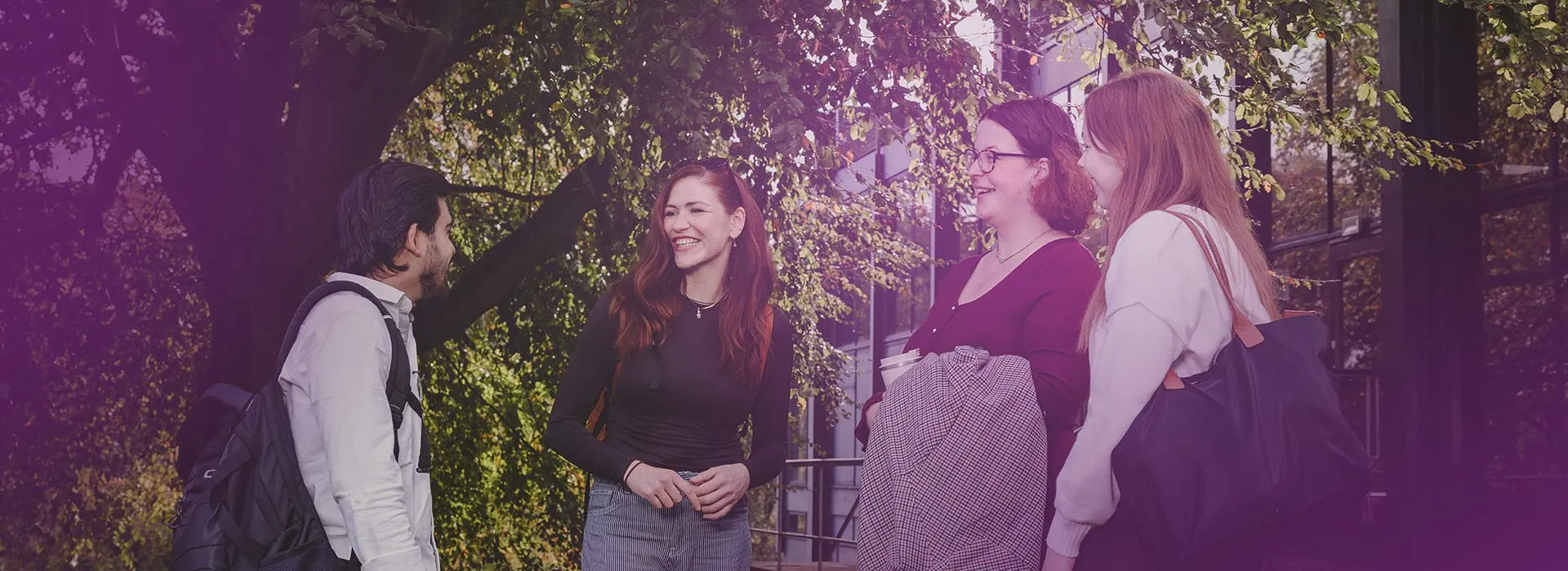 Four students talking outside of Gray's School of Art on the RGU campus