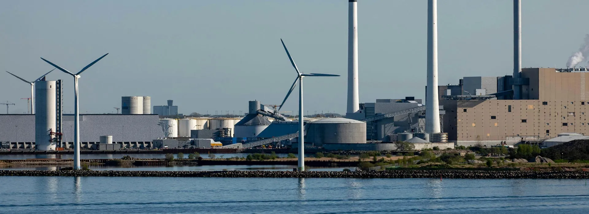 wind turbines next to a factory