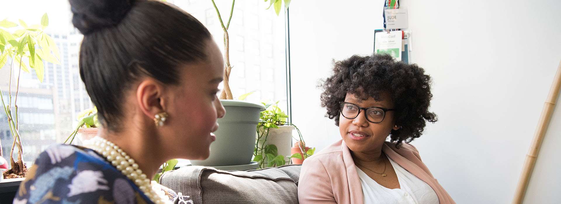 two people having a conversation on a sofa