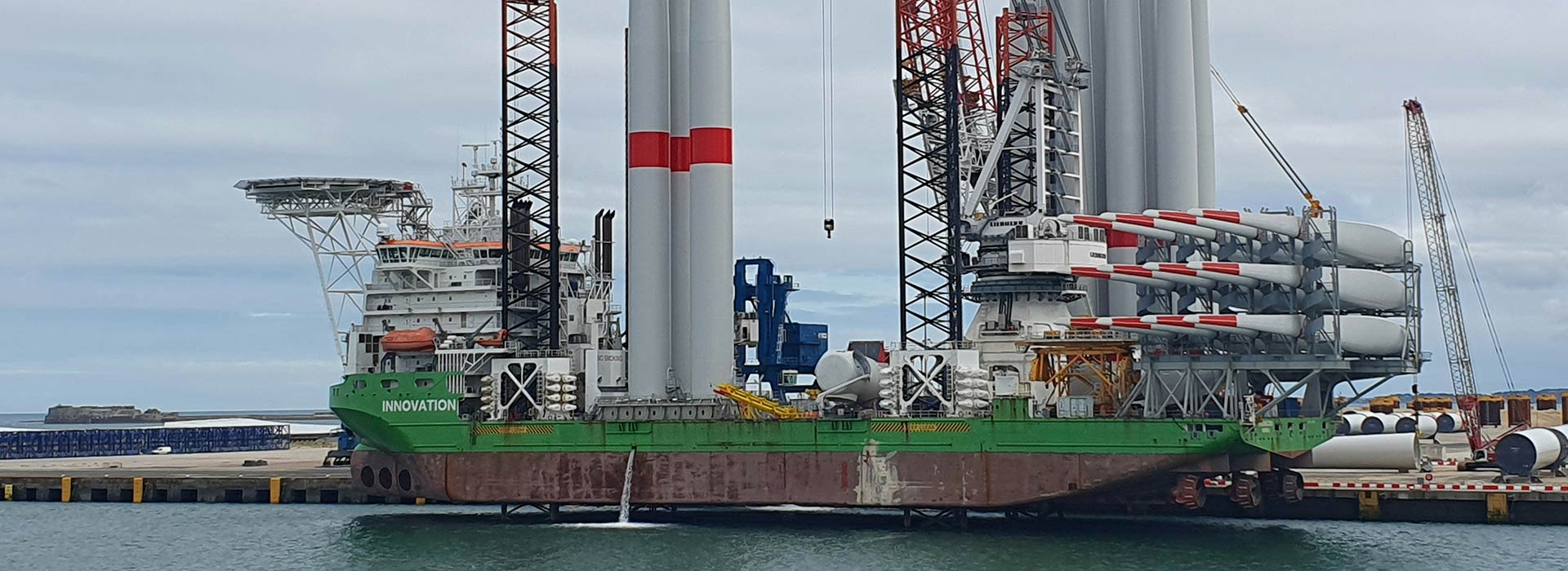 crane boat next to wind turbines