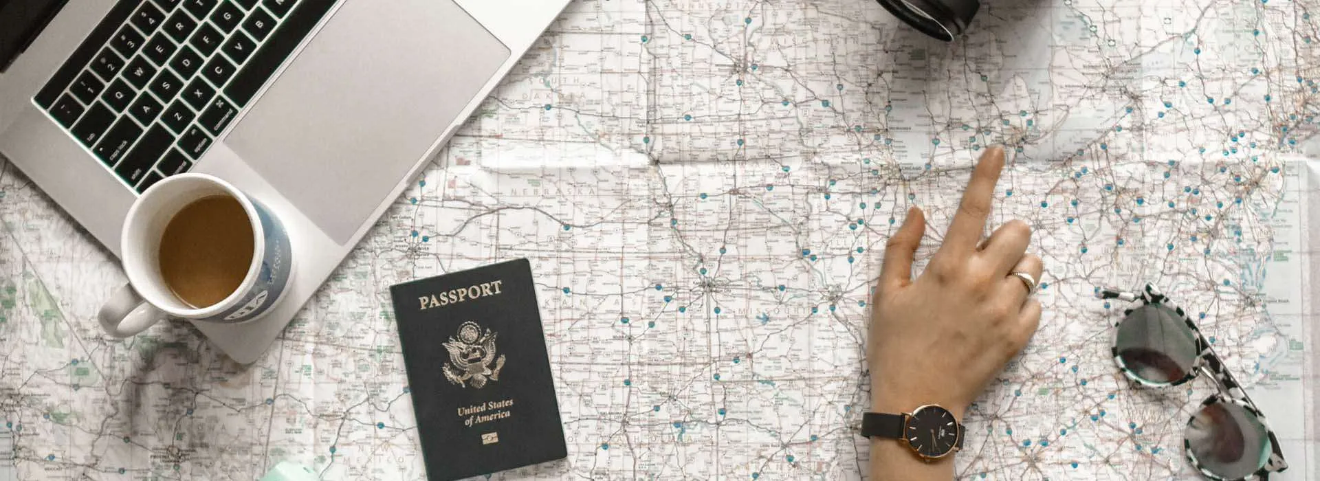desk with laptop, passport and coffee