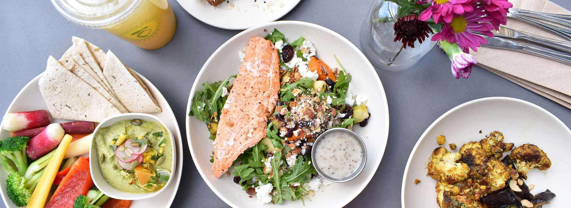 healthy meals on a table with salmon, salad and vegetables