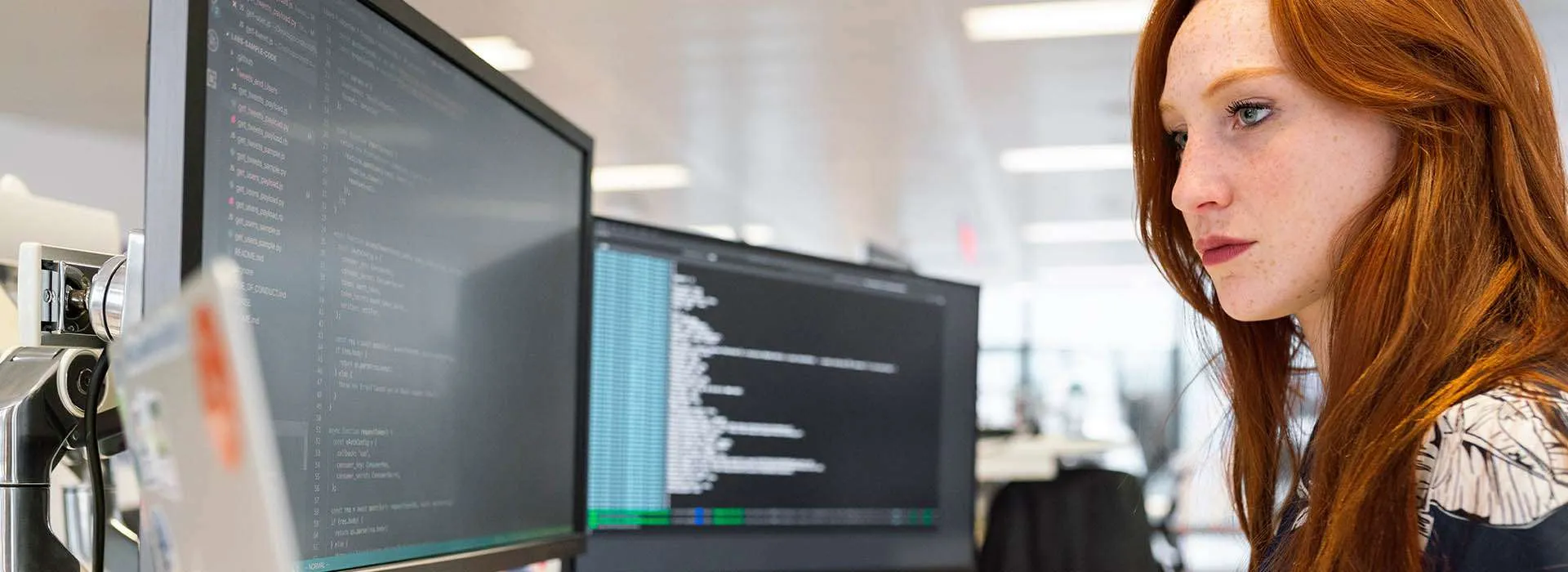 woman looking at code on her computer