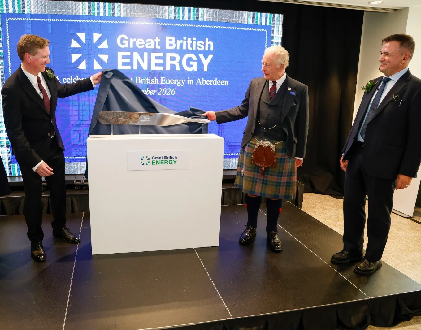 Three people unveiling a commemorative plaque at GB Energy in Aberdeen