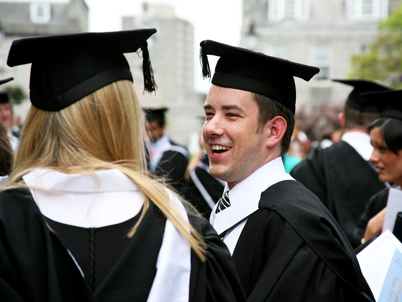 Graduates smiling at one another