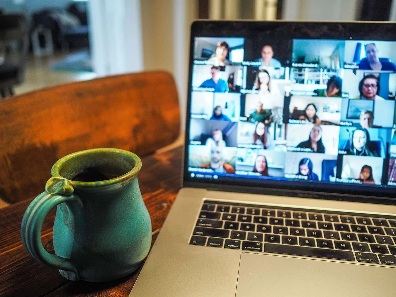 Coffee mug next to laptop showing Zoom call