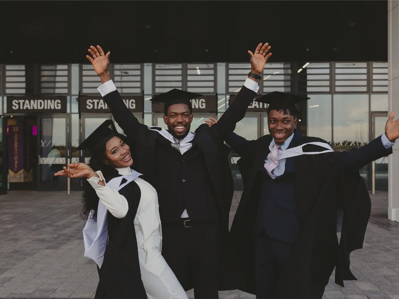 Three graduates celebrating