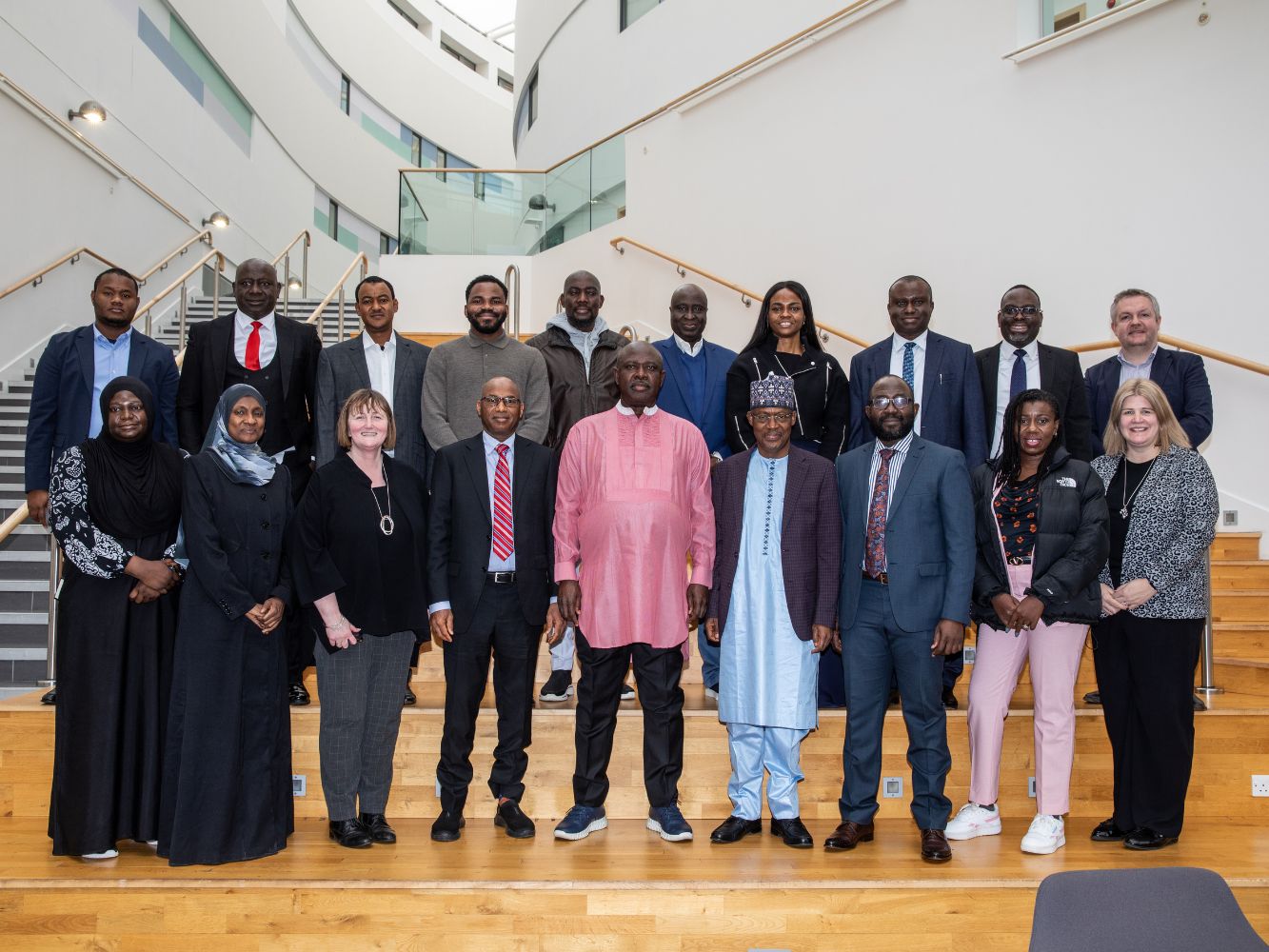 Delegates from both parties pose in the back atrium at RGU