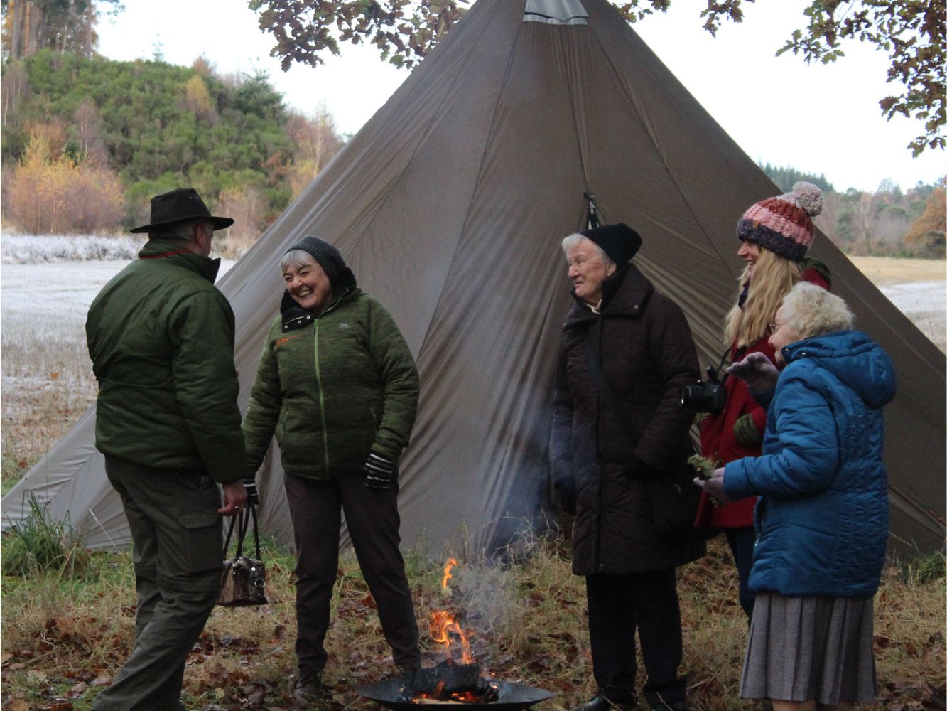A group of elders standing next to a tent