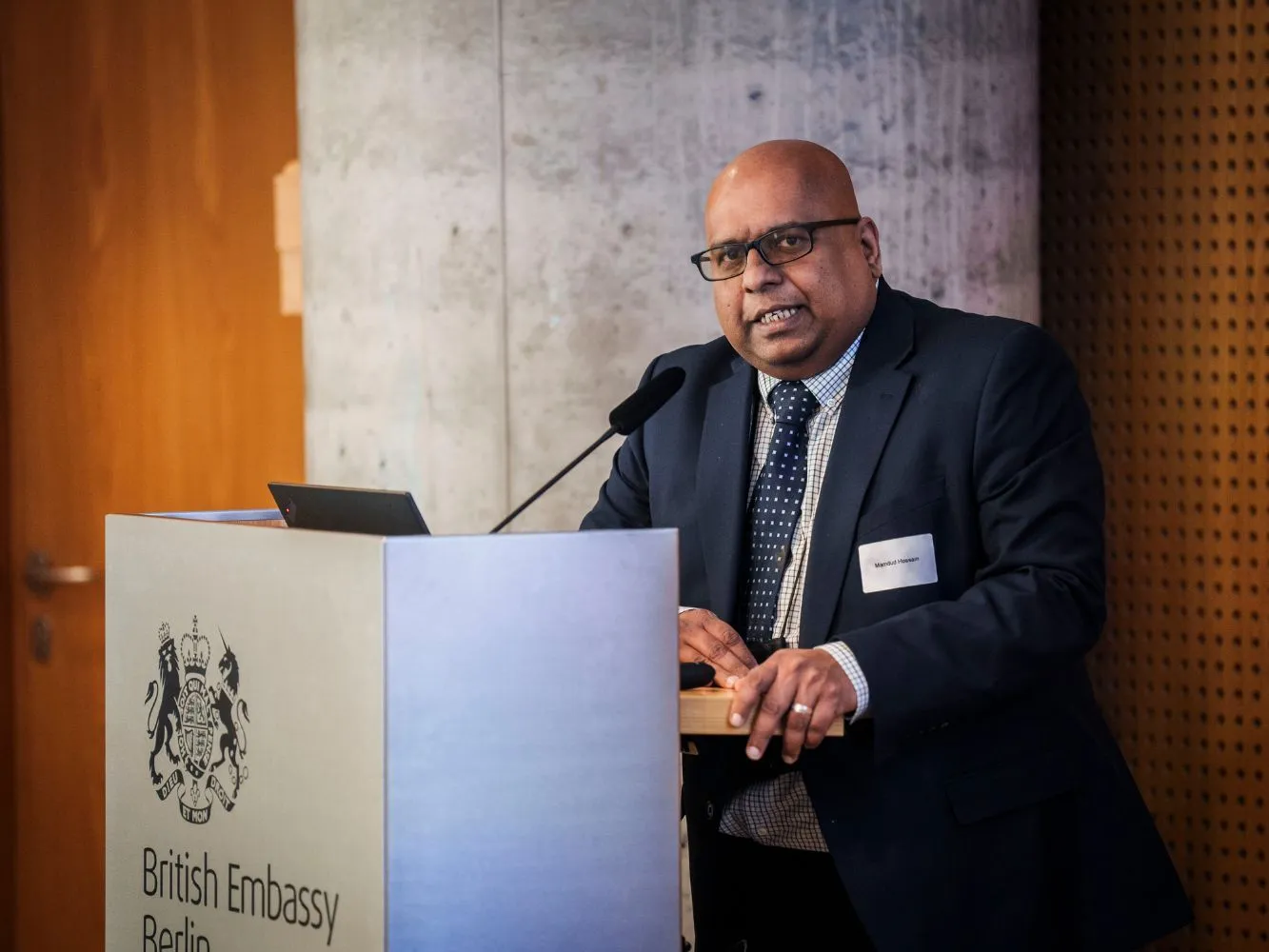 Professor Mamdud Hossain speaking at a podium