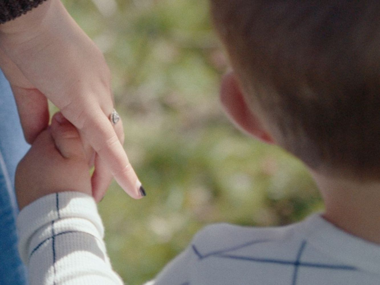 Image shows mother holding a child's hand