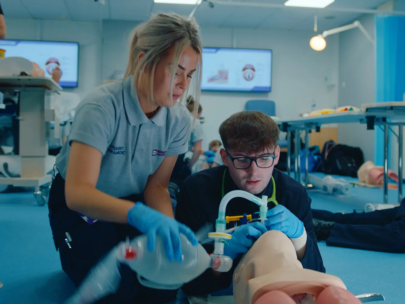 students administering oxygen mask to dummy