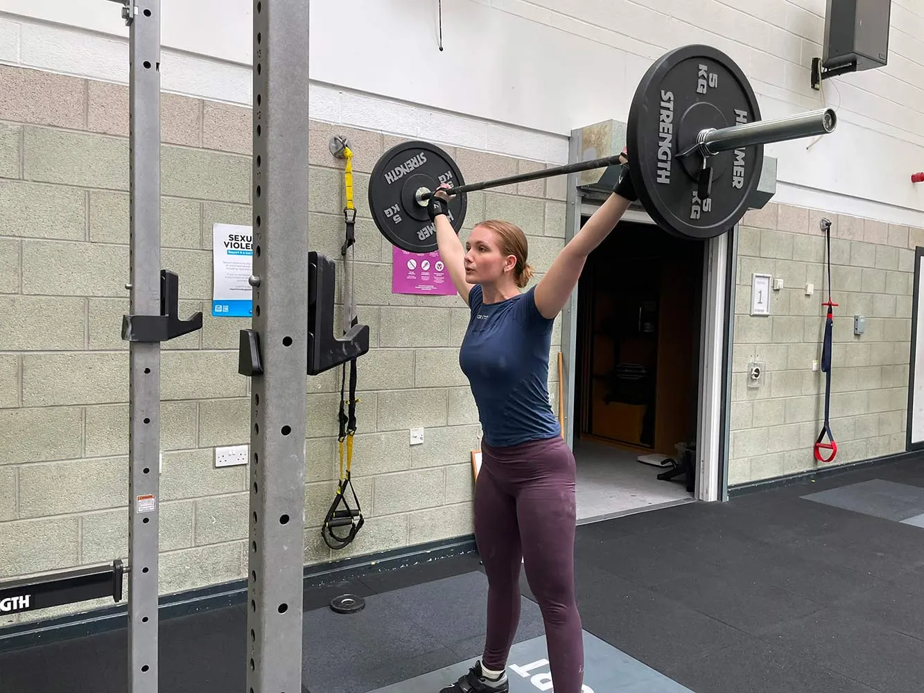female student lifting barbell