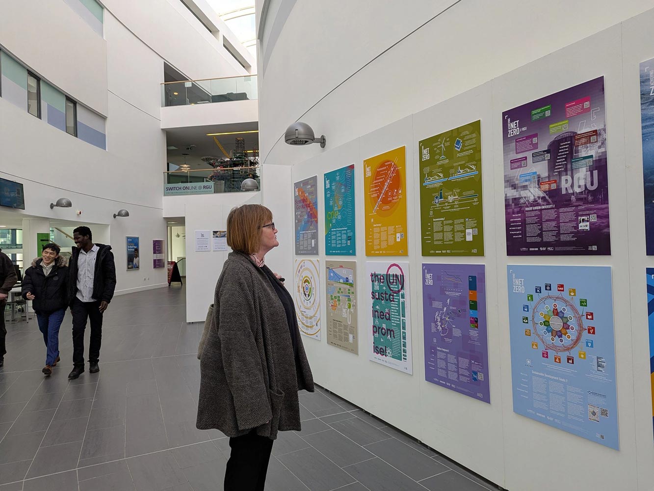 woman looking at wall of posters about achieving net zero