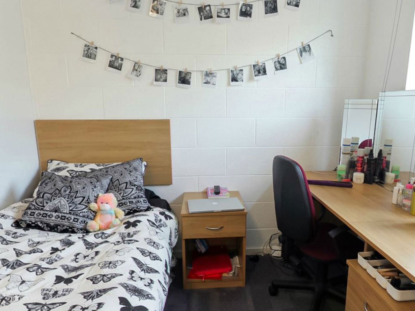 bedroom with bed, side table and desk