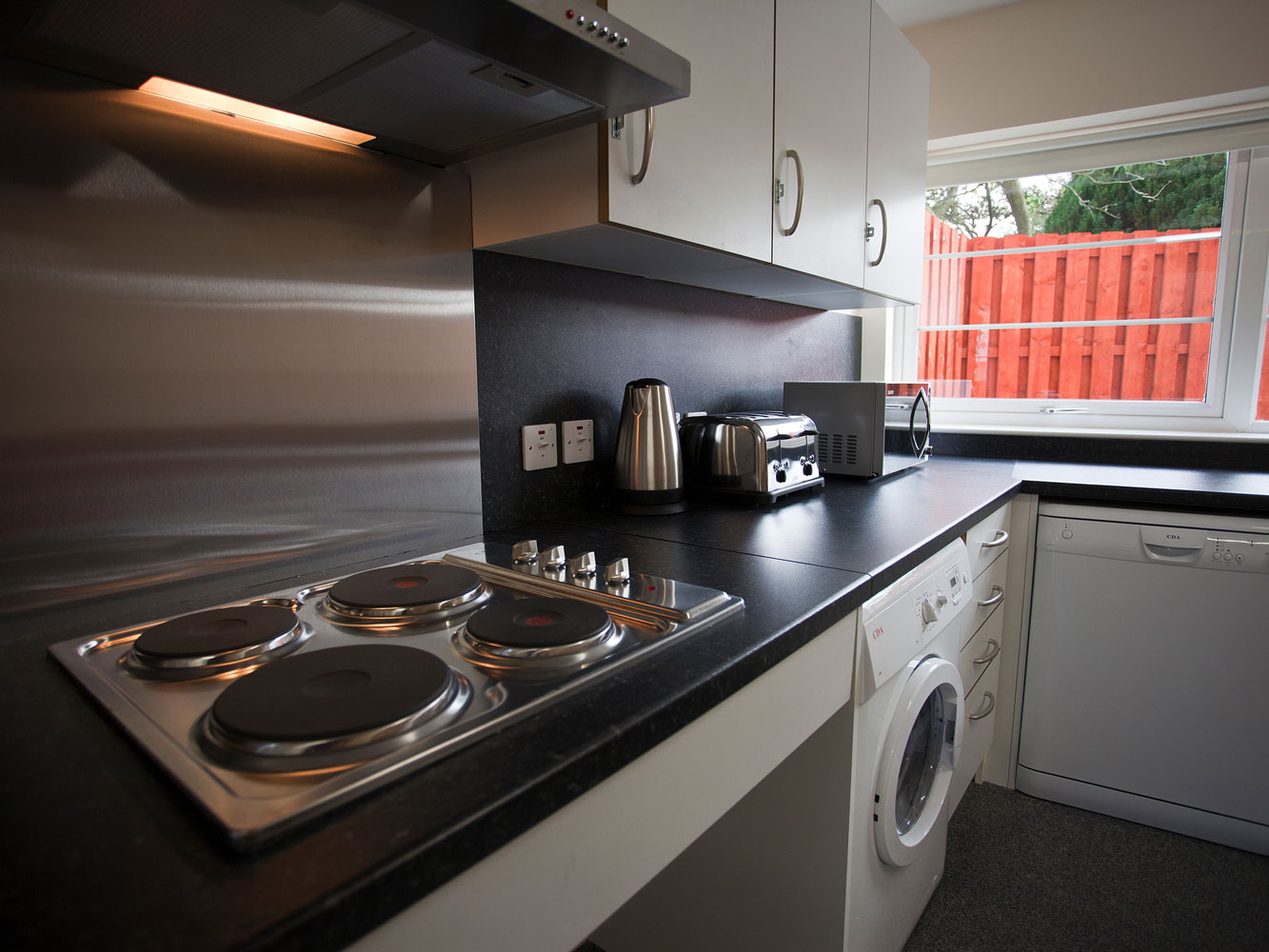 kitchen with hob, kettle, toaster, microwave, washing machine and dishwasher