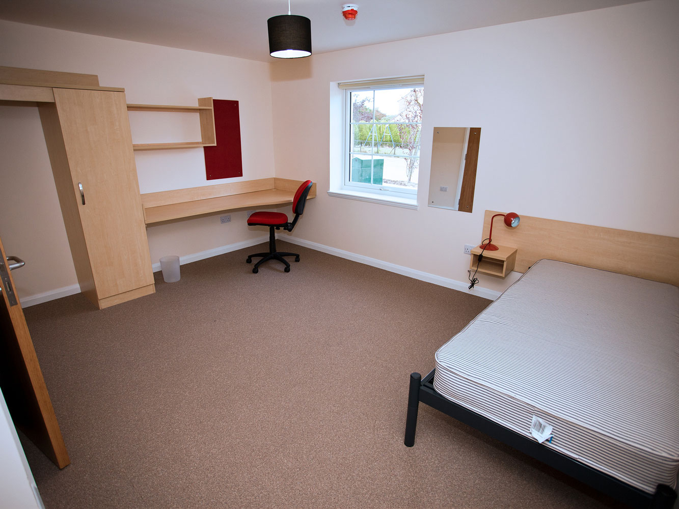 bedroom with double bed, desk and storage space