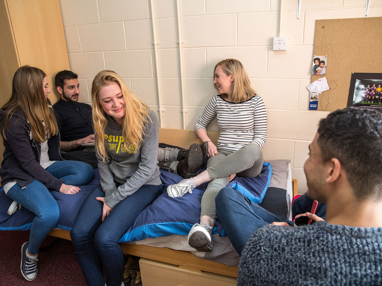 group of students socialising in bedroom