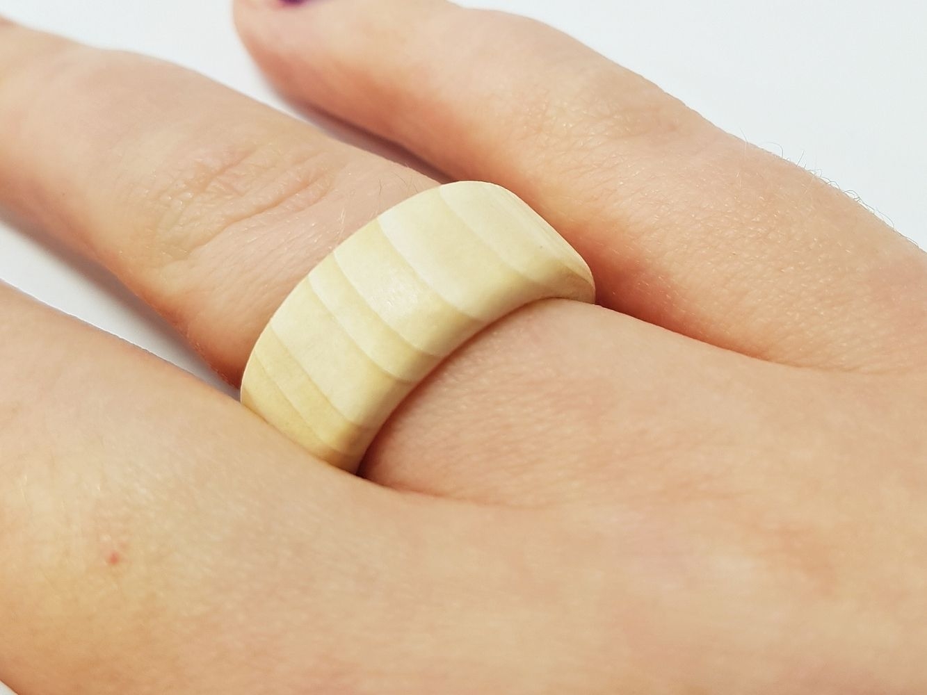 Ring made with light wood worn on finger