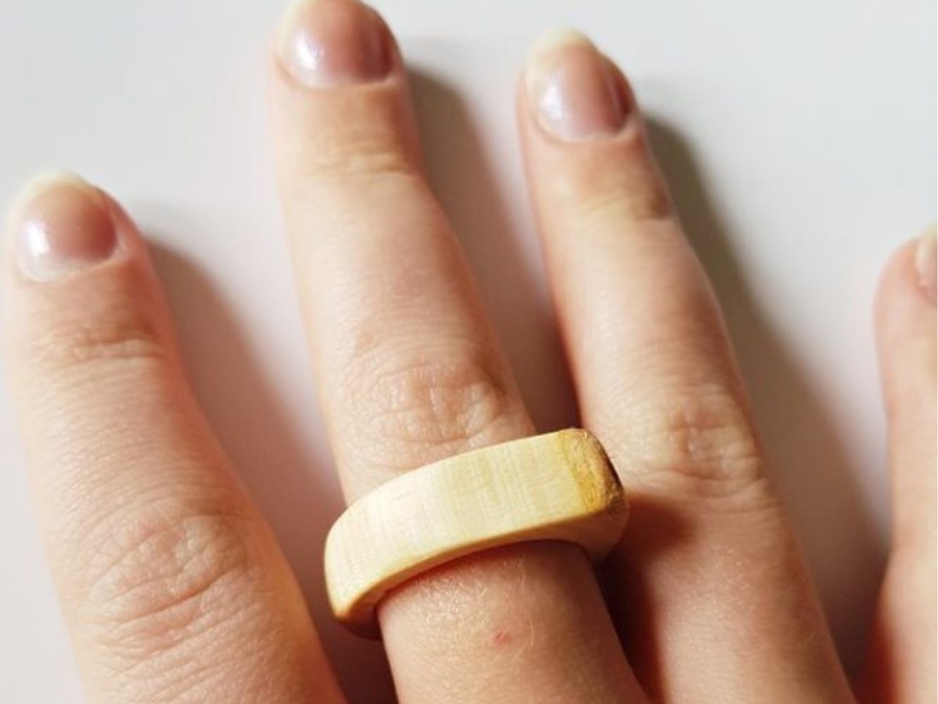 Ring made with light wood worn on finger