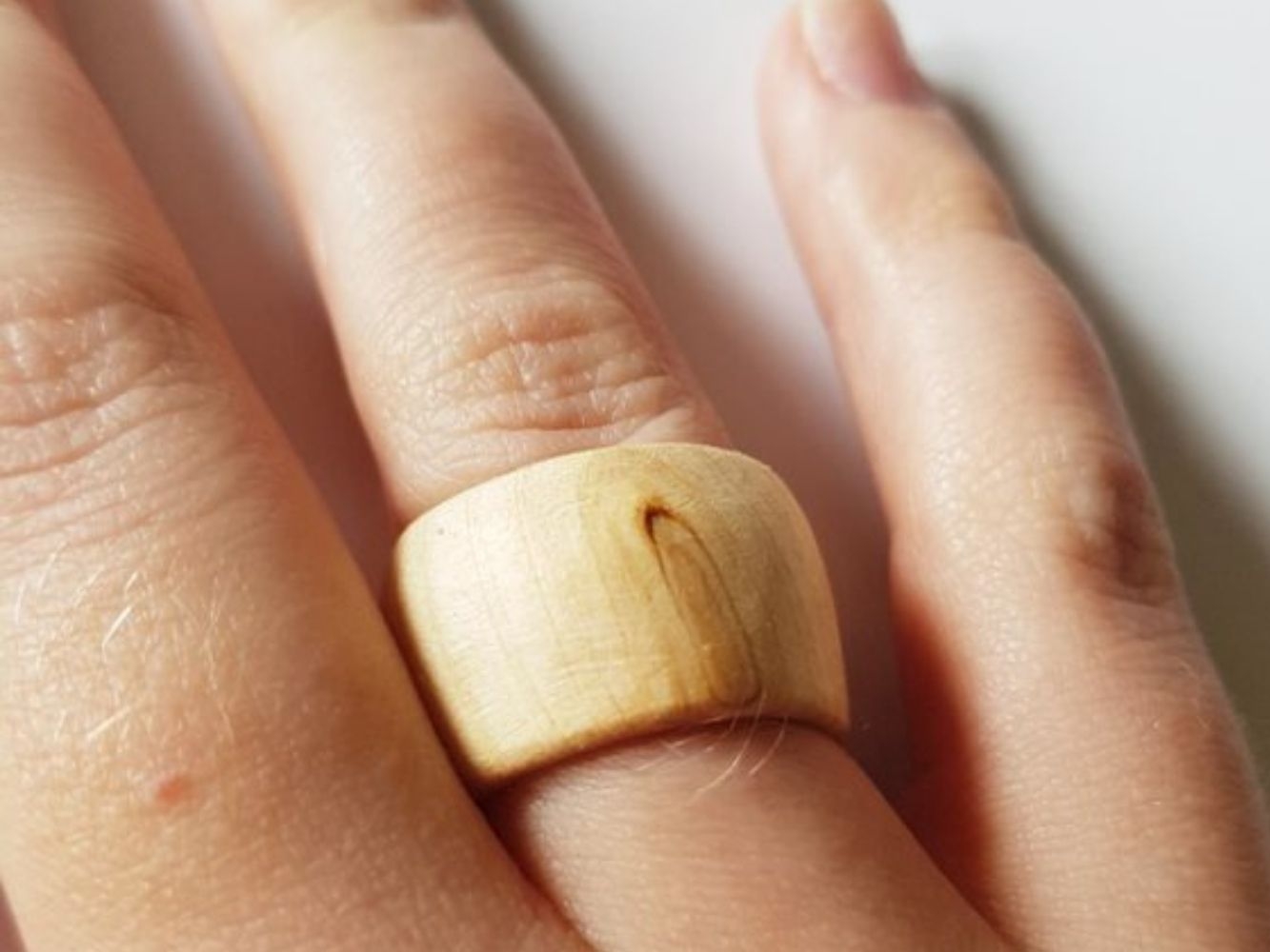 Ring made with light wood worn on finger