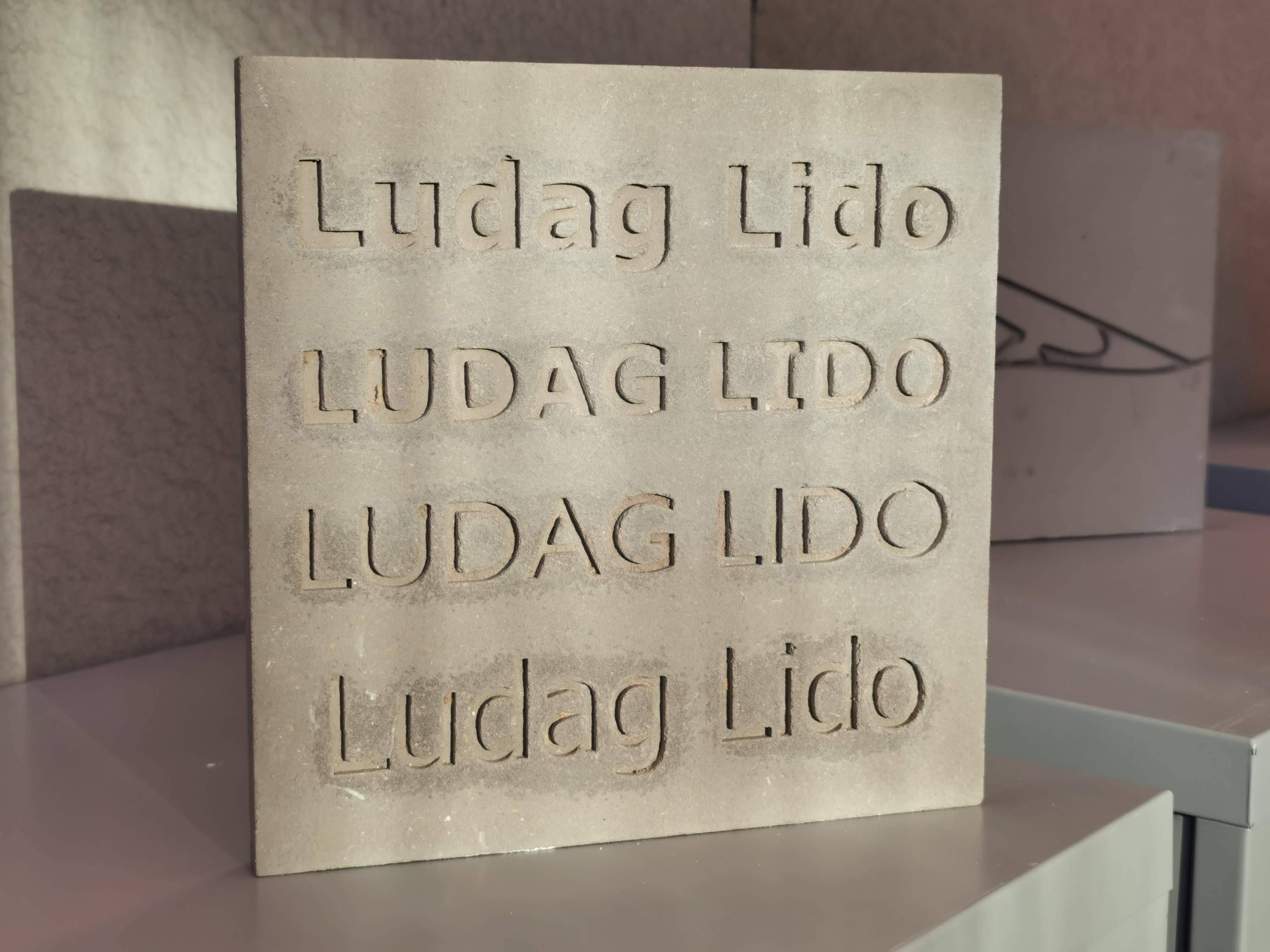 Stone display with words 'ludag lido' engraved on it