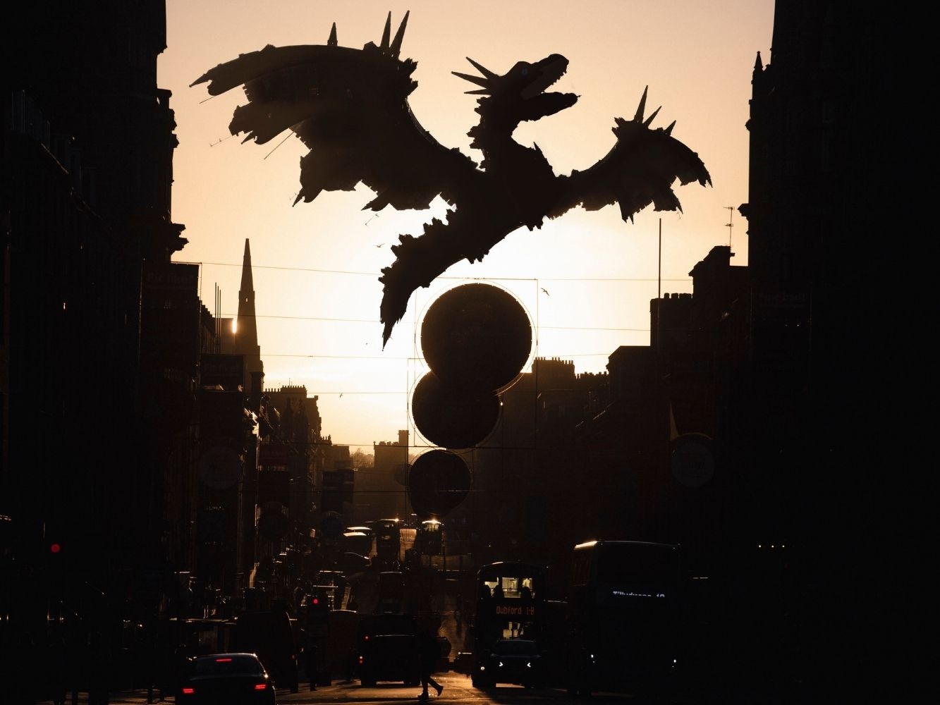 Photograph of Aberdeen's Union Street at sunset with a shadowed dragon in the skyline