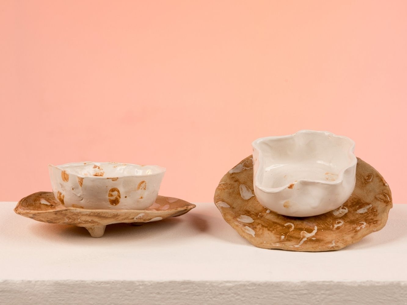 Two clay bowls on top of plates