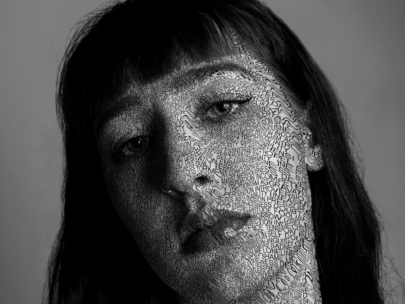 Black and white portrait of Keira Thomson with 'damaging phrases' on her face