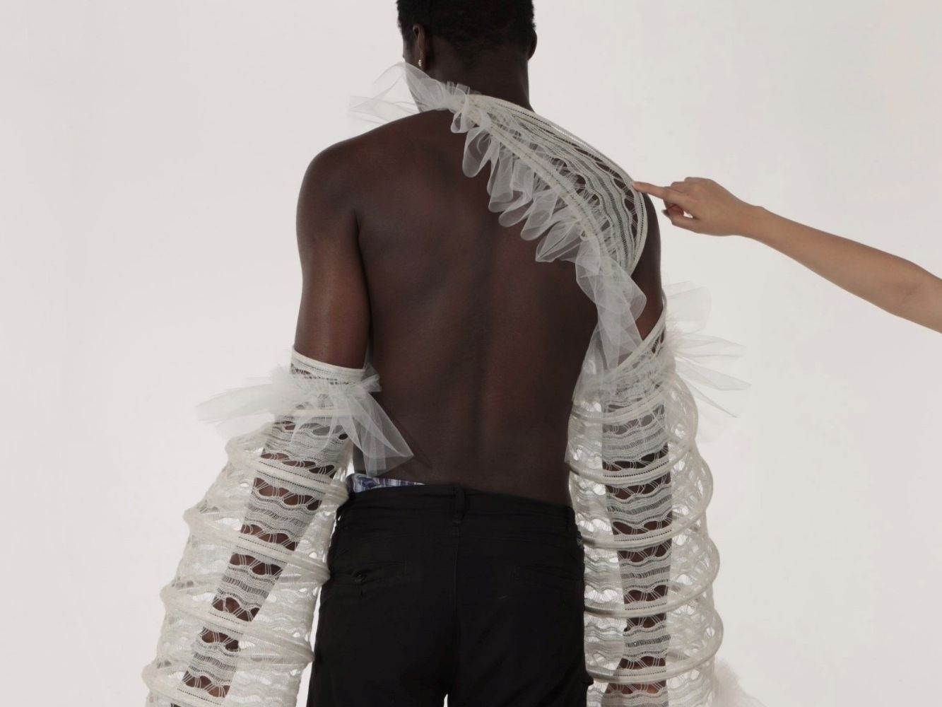 Back of knitted clothing item worn by model, designed to look like a marine organism