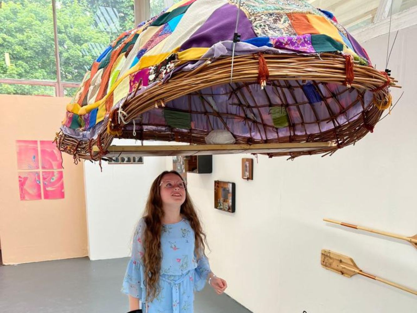 Kitty Donovan looks at art piece installed on the ceiling of a gallery